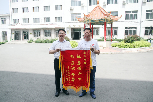 校友代表向学校赠送锦旗.jpg